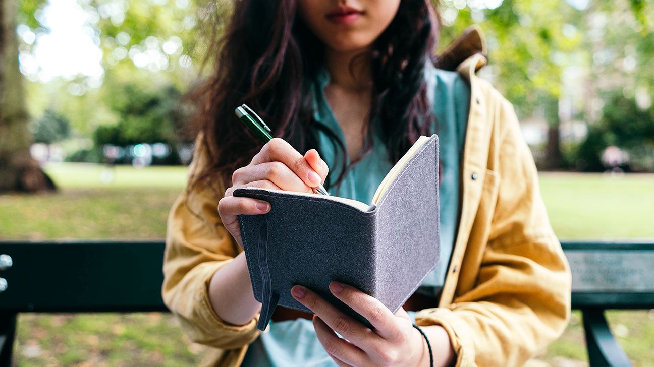 one-small-step-eczema-triggers-01-female-writing-in-journal-on-bench