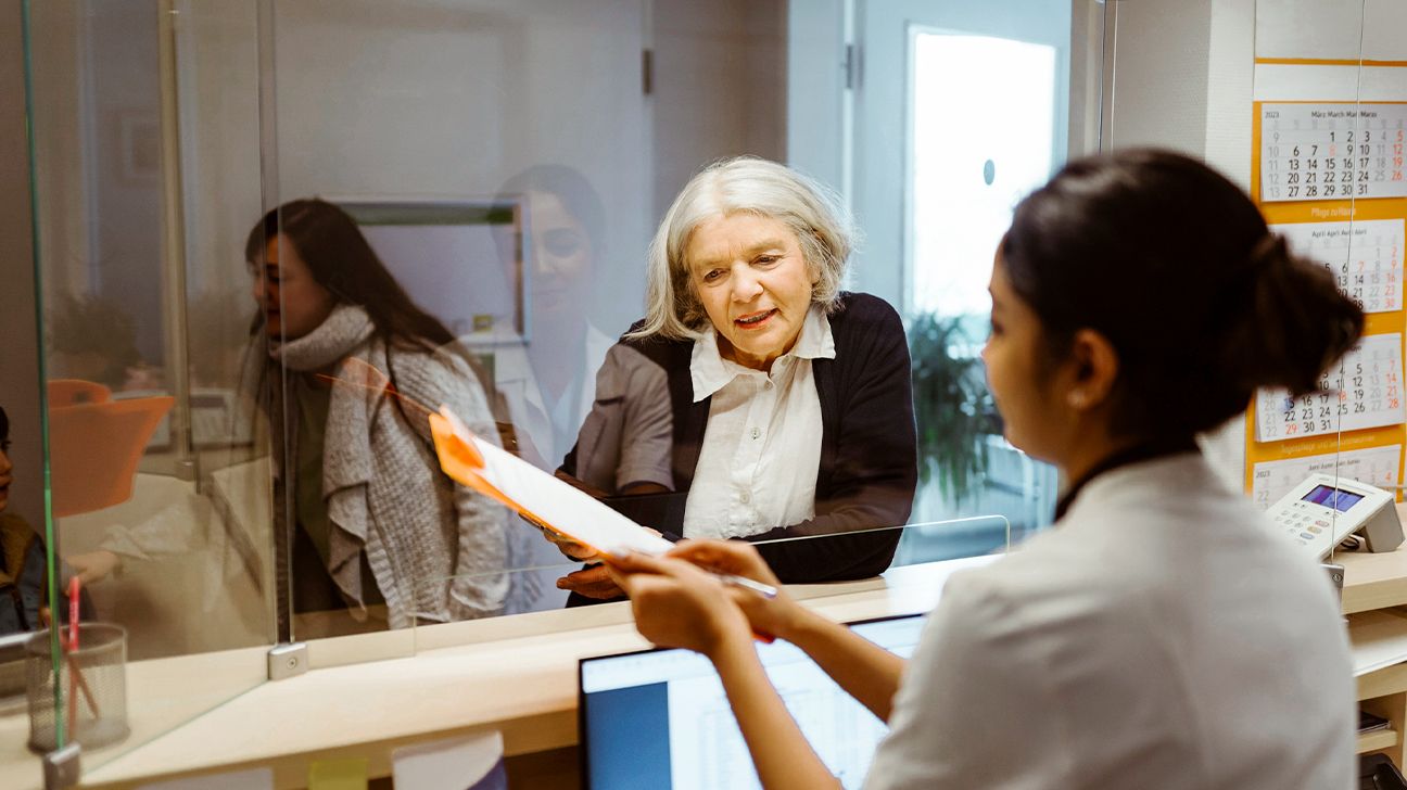 A healthcare professional going over a form with an older female