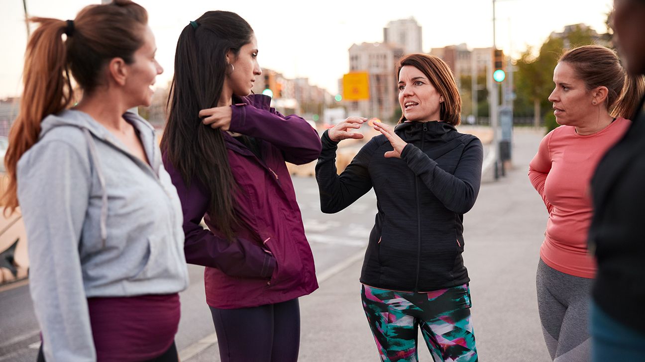 Female friends exercising and talking outside