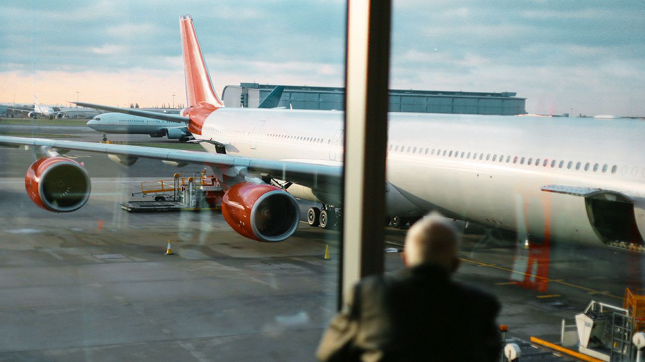 man at airport waiting at the boarding gate