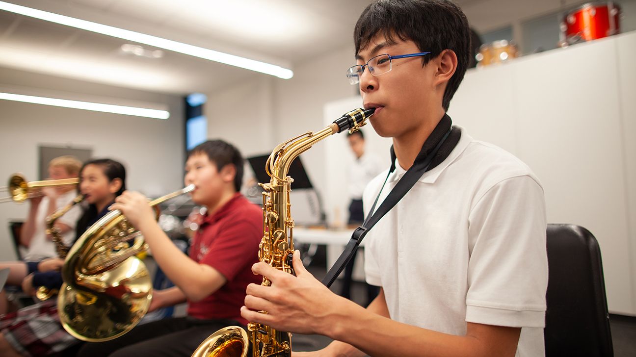 teenager playing the saxophone in band class
