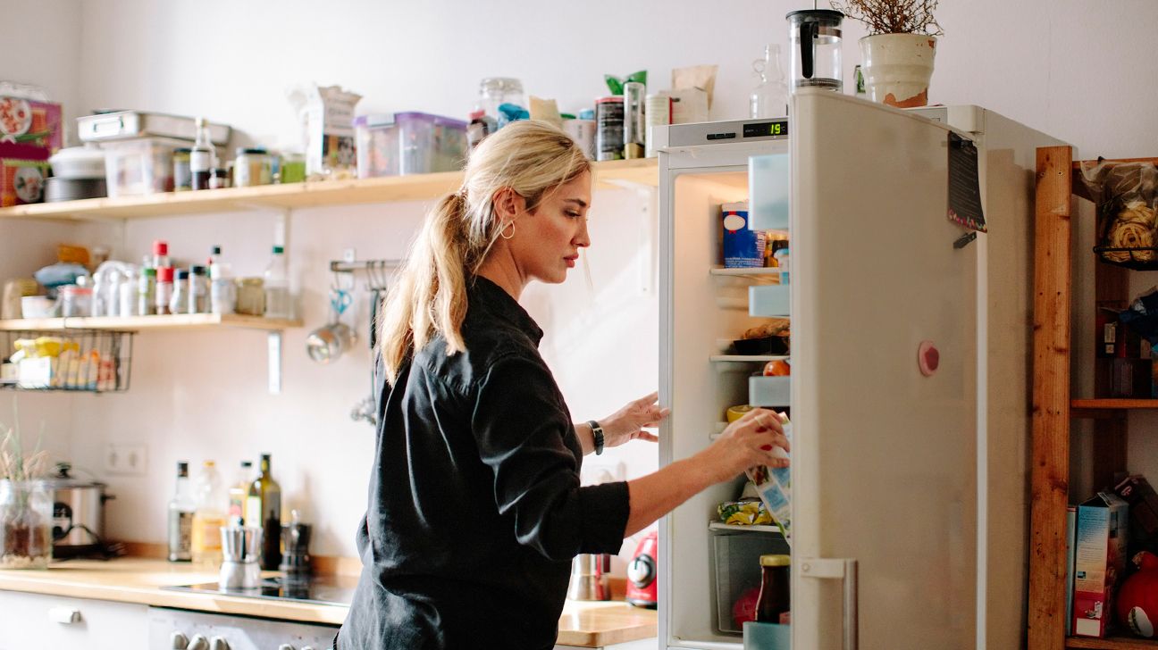 adult cleaning out their refrigerator