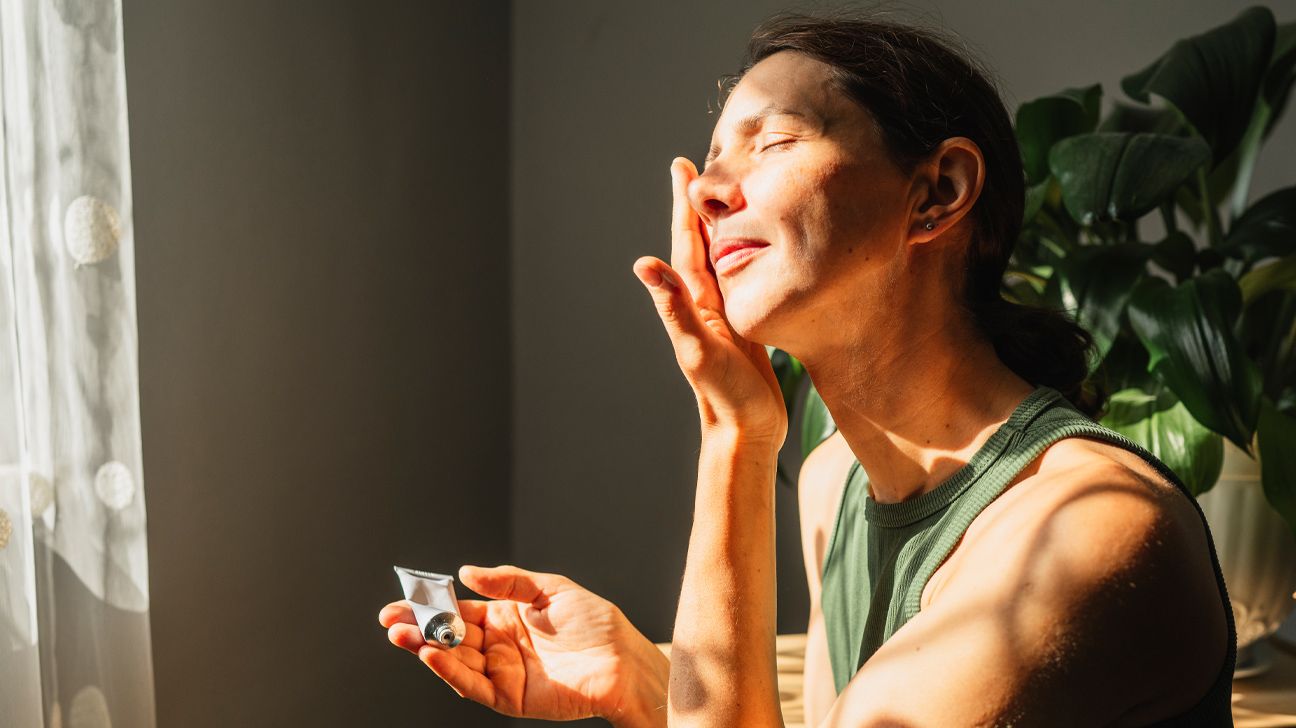 older adult female putting a skin product on her face