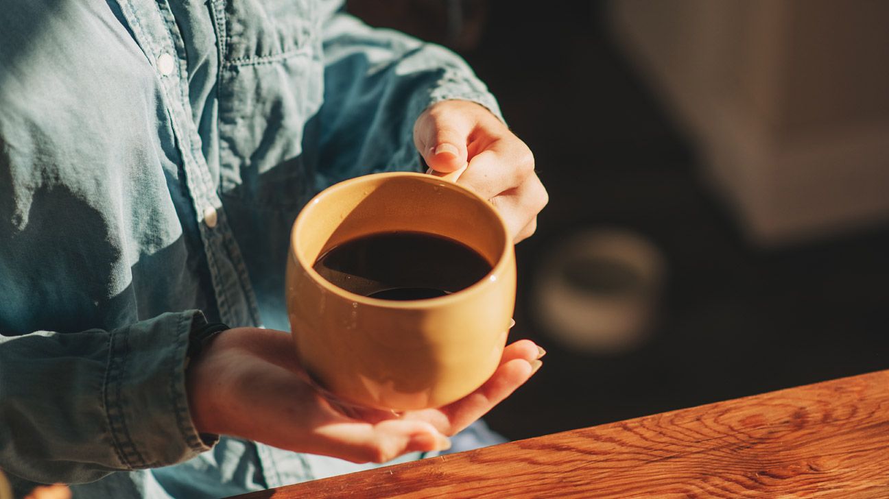 Close up of black coffee in a yellow mug
