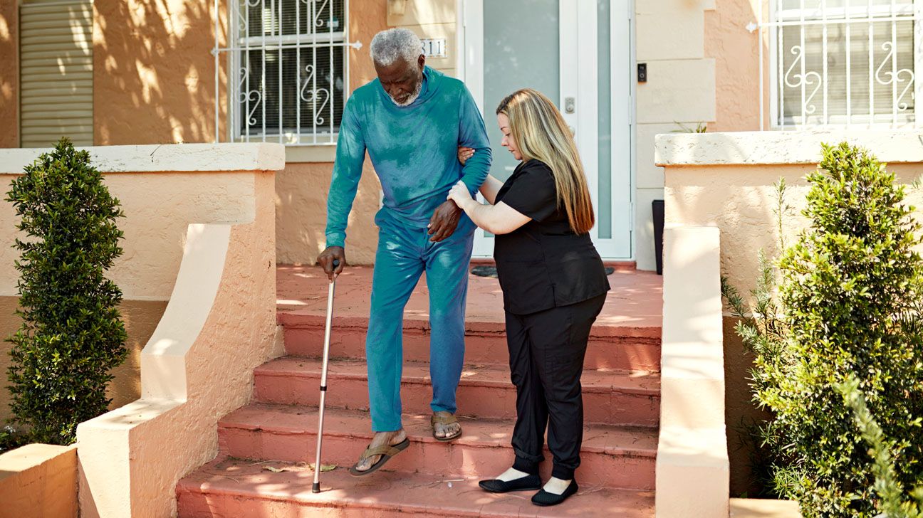 Older male gets assistance walking down steps Older male gets assistance walking down steps