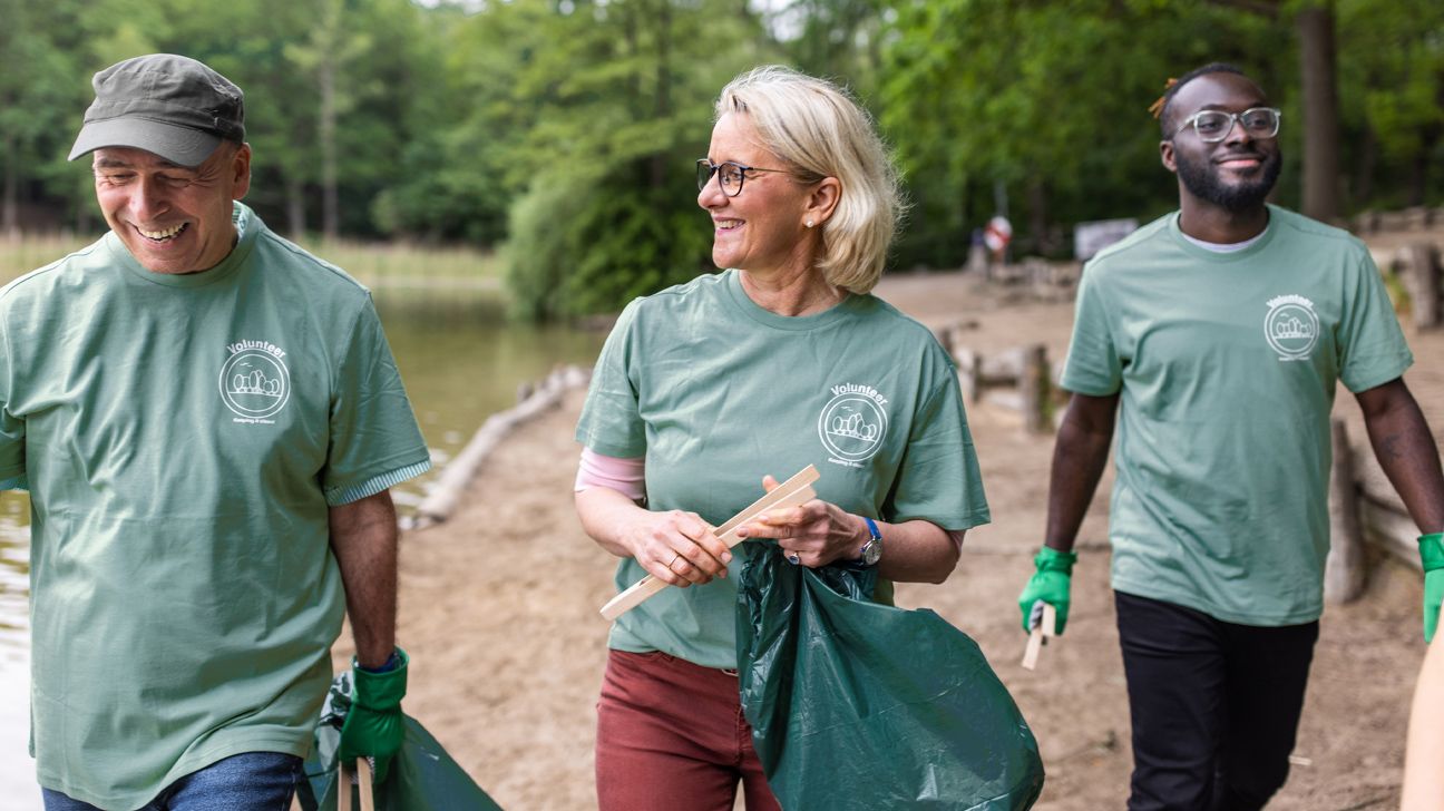 older adult female volunteering to pick up trash outside with others