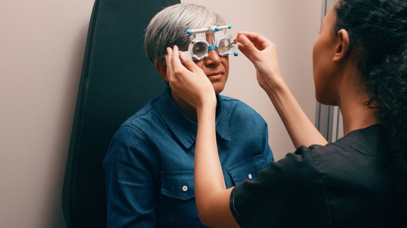 Female receives eye exam from technician