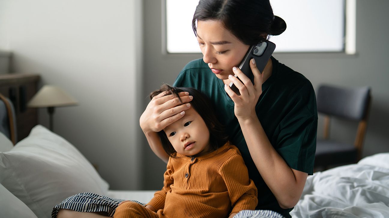 Woman with a toddler on her lap calling a doctor
