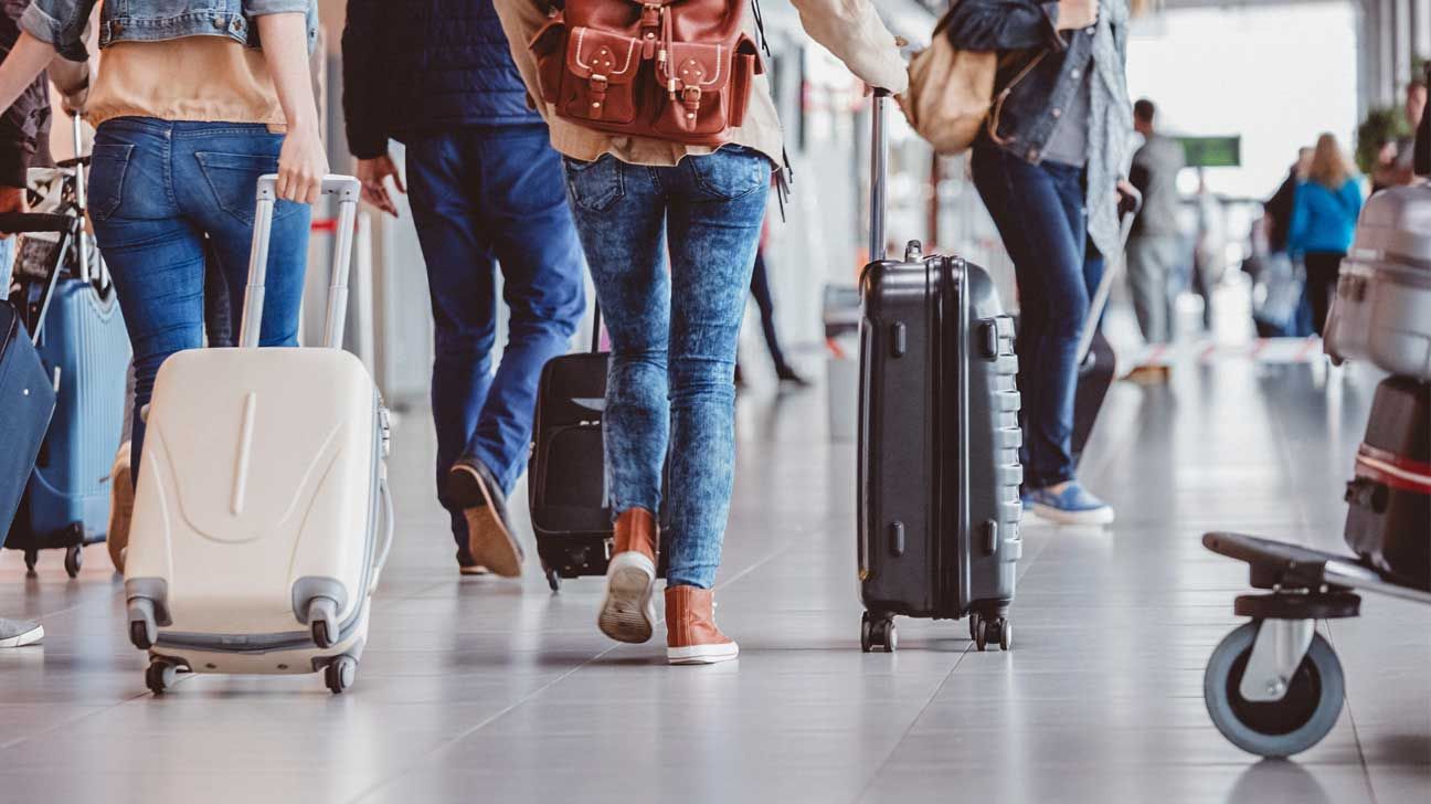 people walking through airport with luggage
