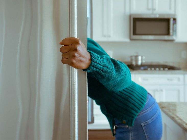 A person leaning in to look in a fridge.