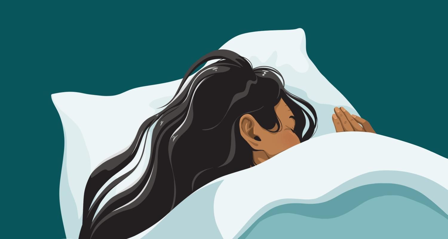 woman sleeping underneath the covers in bed