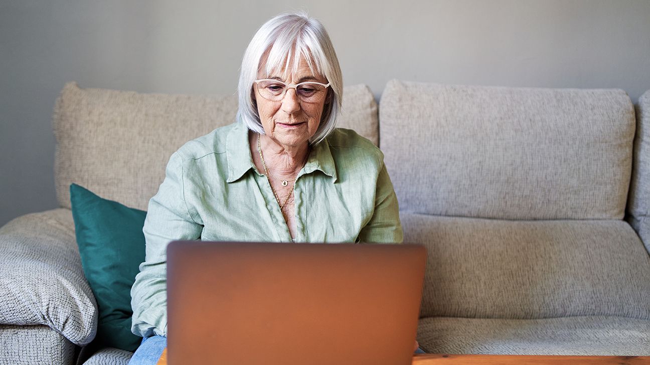 Older female using laptop on couch