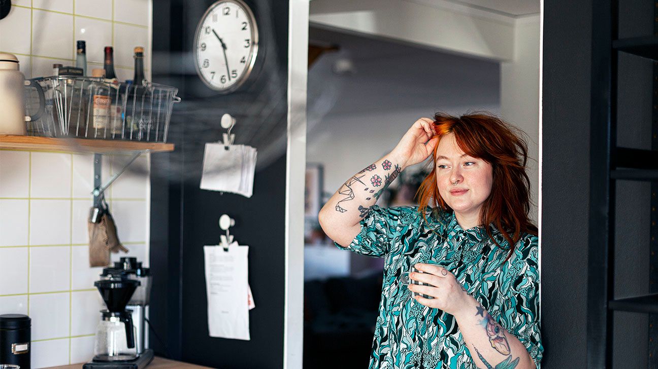 Female looks at reflection of self and clock in mirror