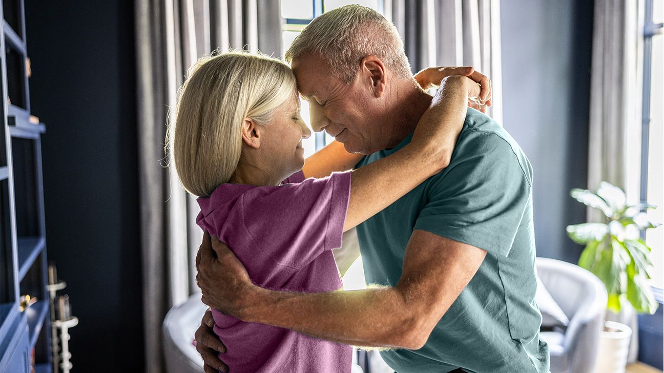 Older couple embracing in bedroom