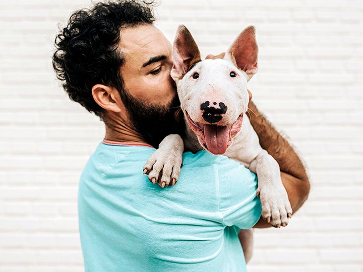 A man is hugging his dog.