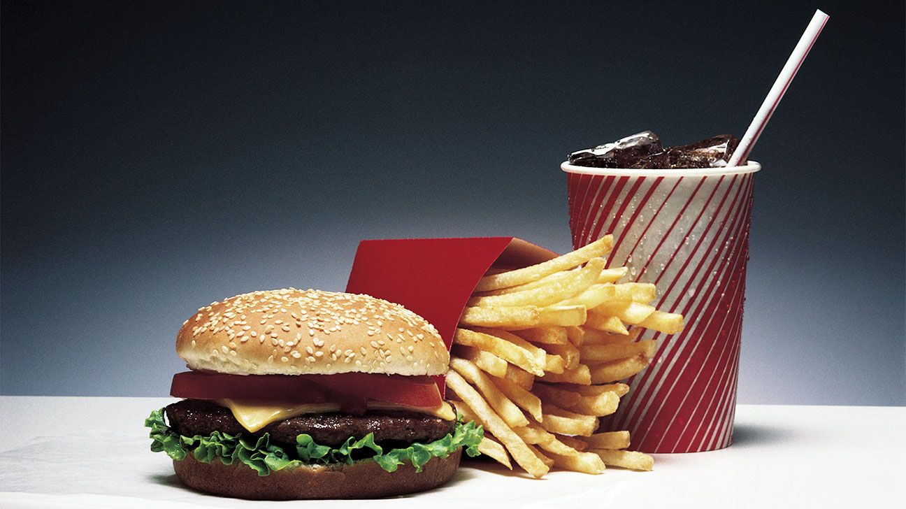 Burger, fries, and soda against a black and white background