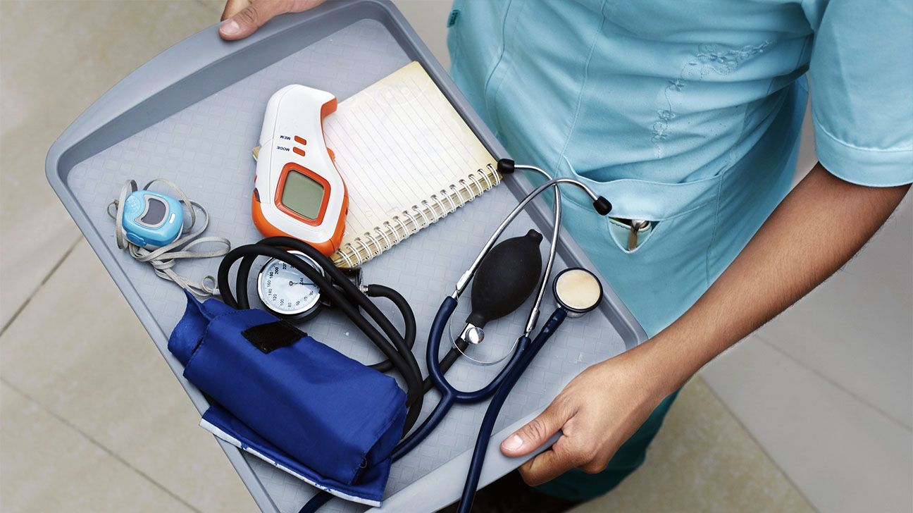 Medical professional holds a tray with heart monitoring instruments