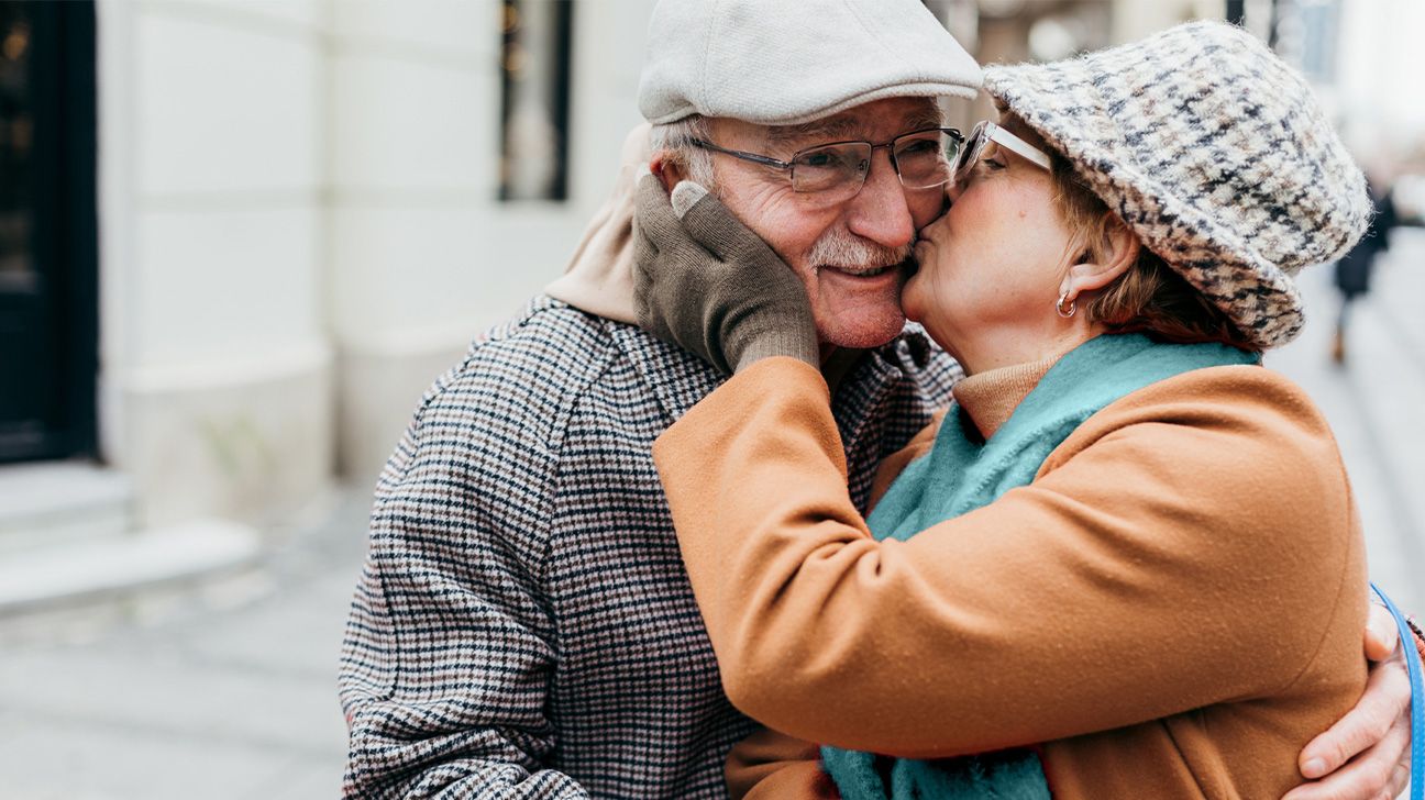 Older couple cuddling outside in a city