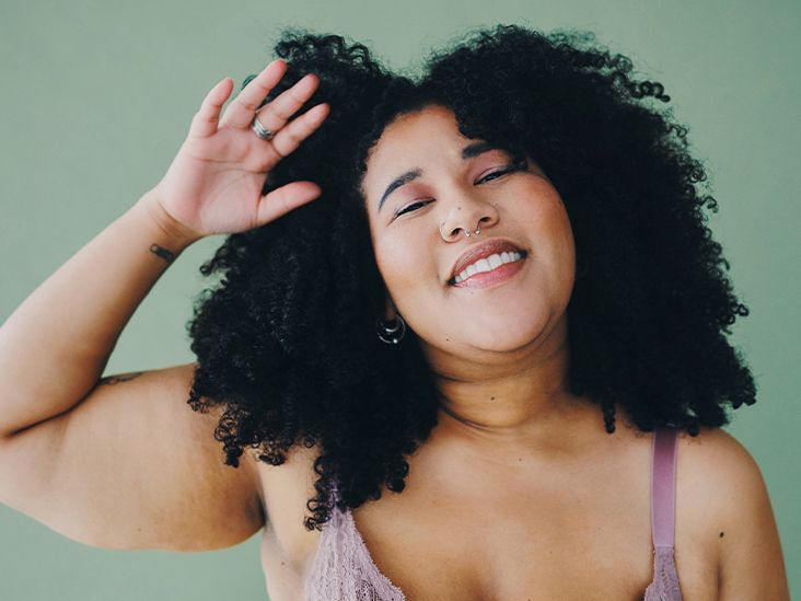 A woman is raising her arm in the air and looking happy.
