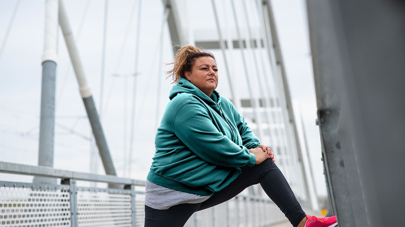 Female stretching on bridge outdoors