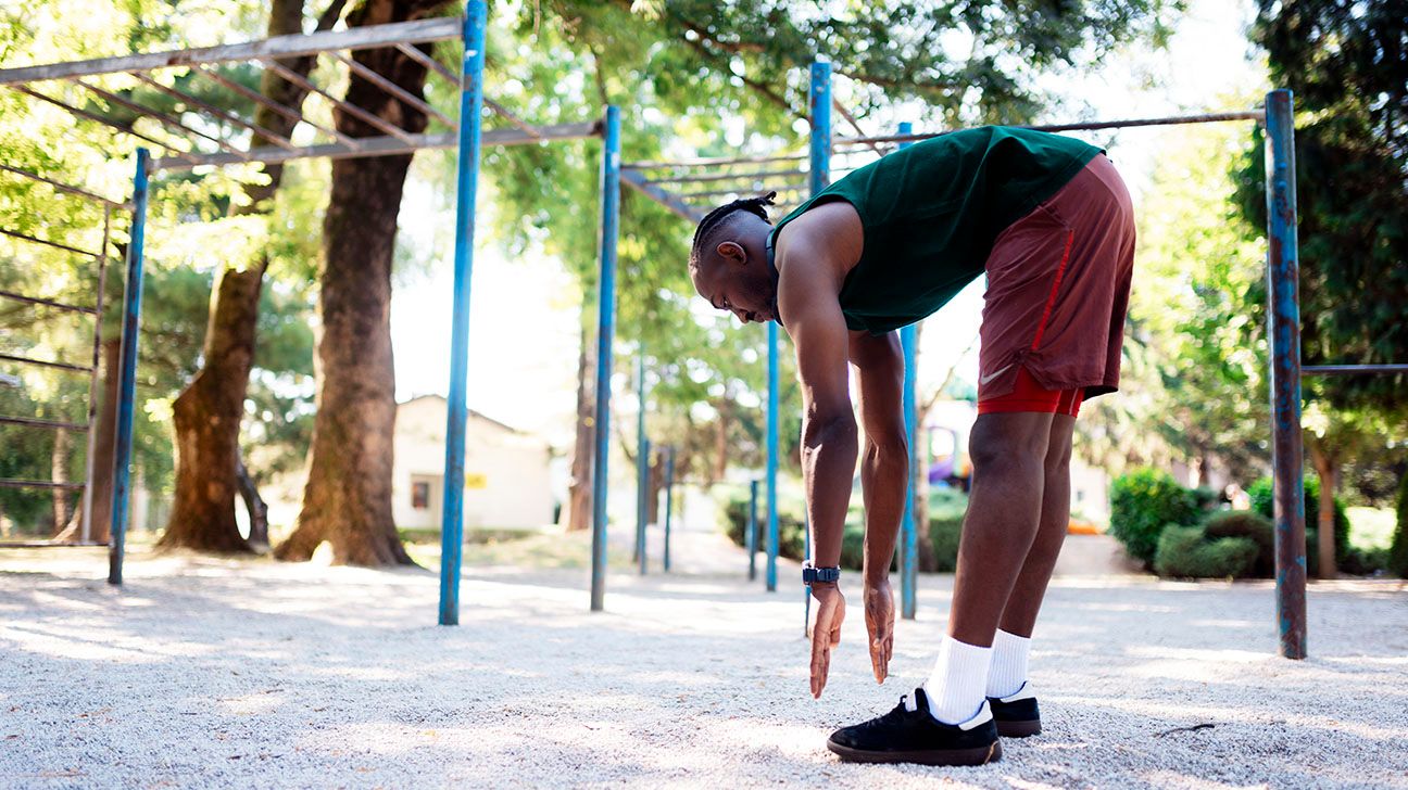 Male stretching outside in a park