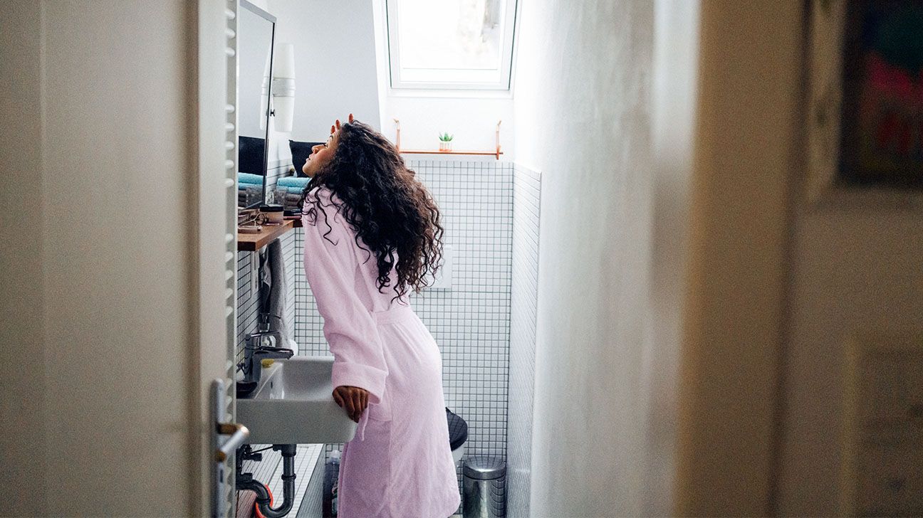 Female in pink robe in bathroom