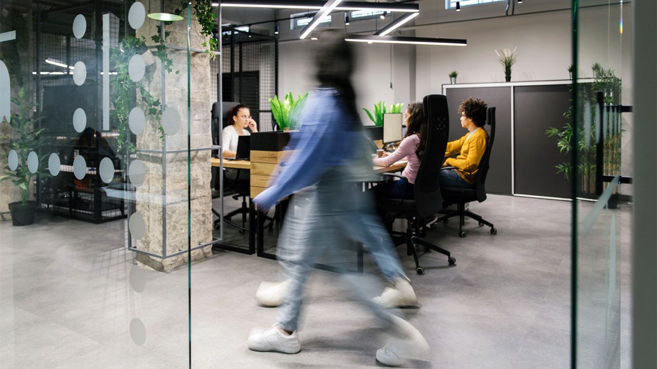 Two people walking through an business office.