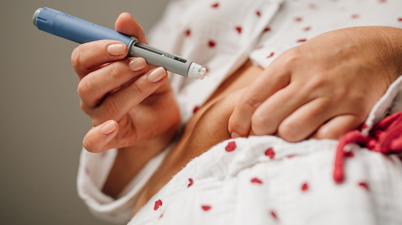 Female injecting her stomach with a GLP-1 pen