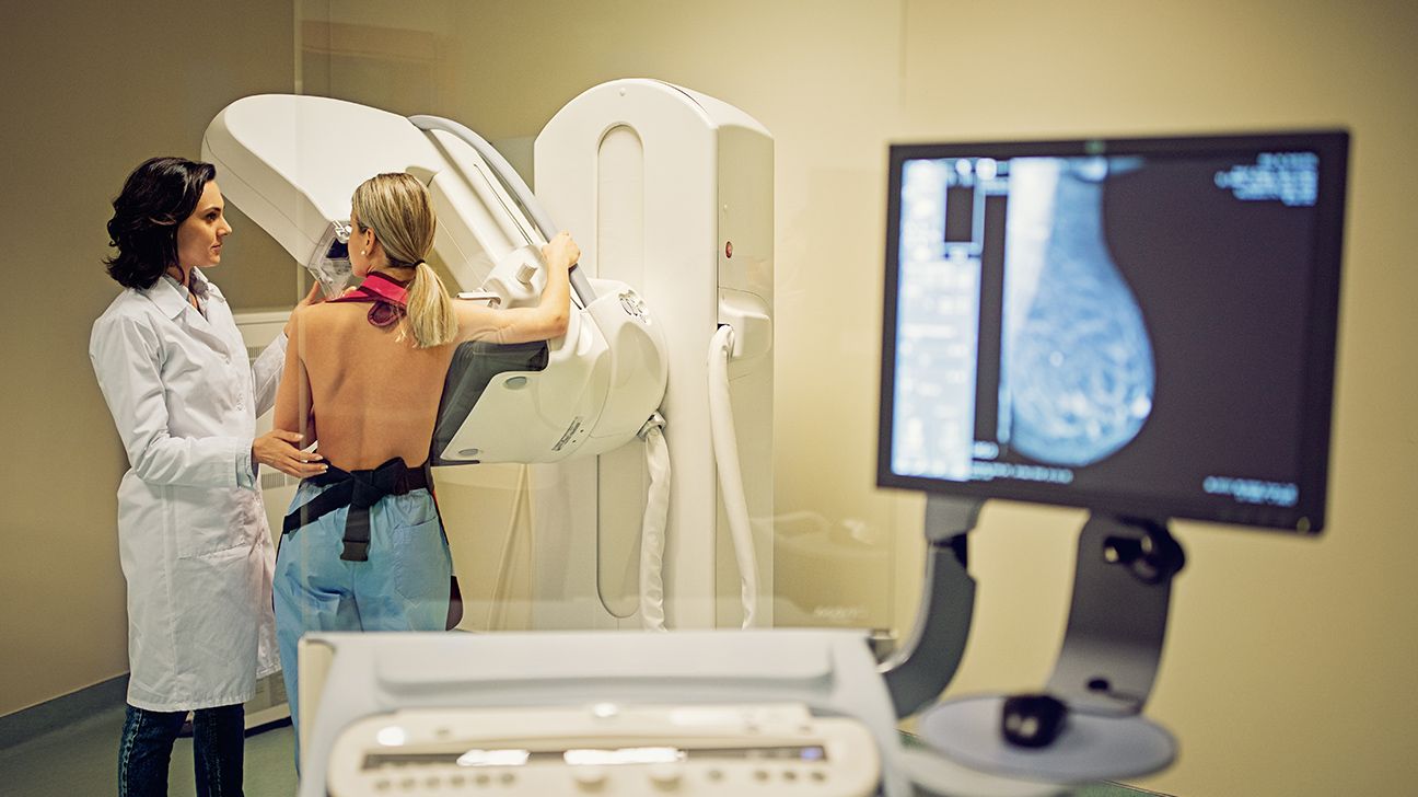 Female receives mammogram with technician