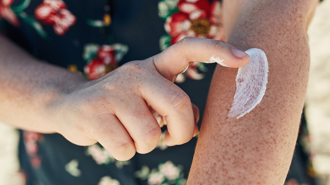 Person putting sunscreen on their arm