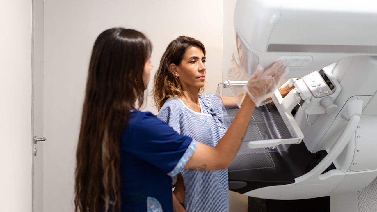 Female undergoing mammogram with technician