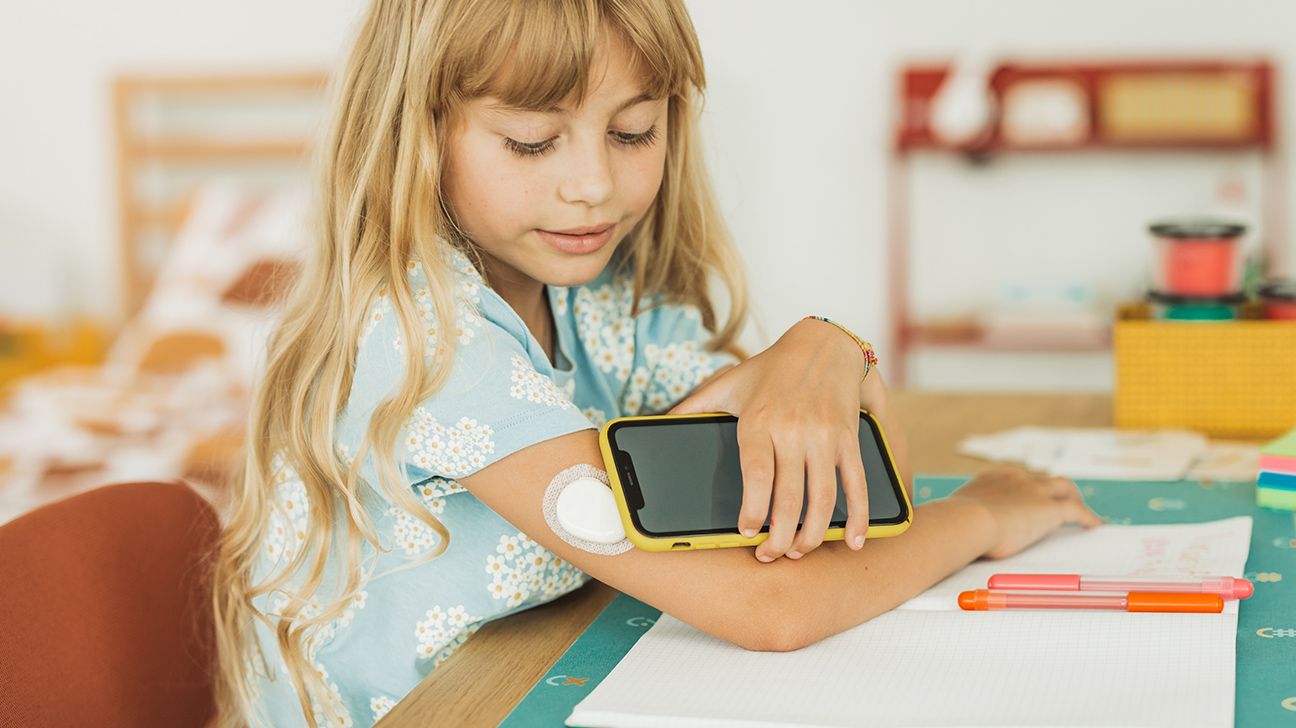 Child checks OTC continuous glucose monitor for diabetes
