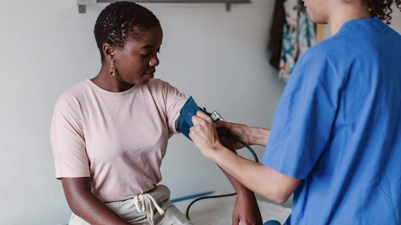 Young female getting blood pressure checked by nurse