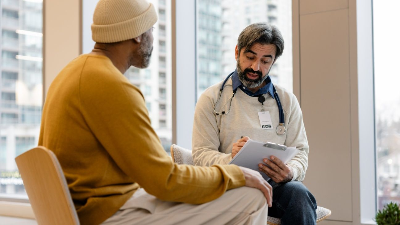 Male patient talking with doctor in office