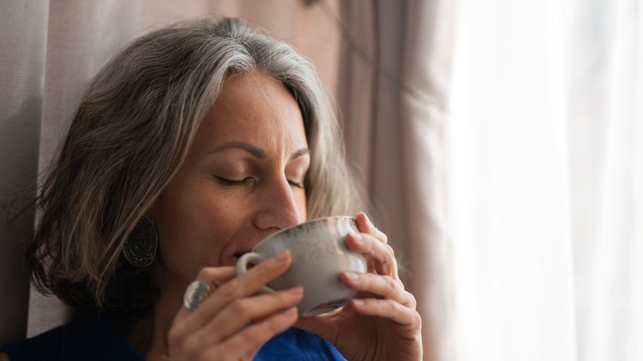 Older female drinking a cup of coffee