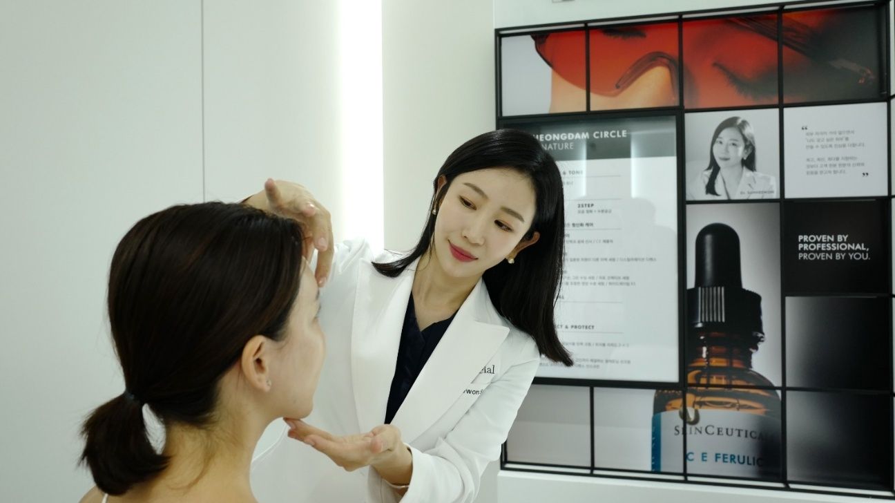 a physician at a aesthetic clinic assesses a patient's skin