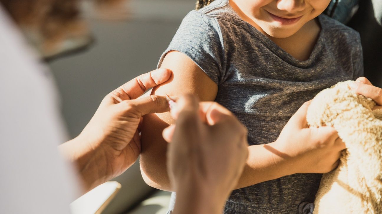 Child receives vaccination in arm