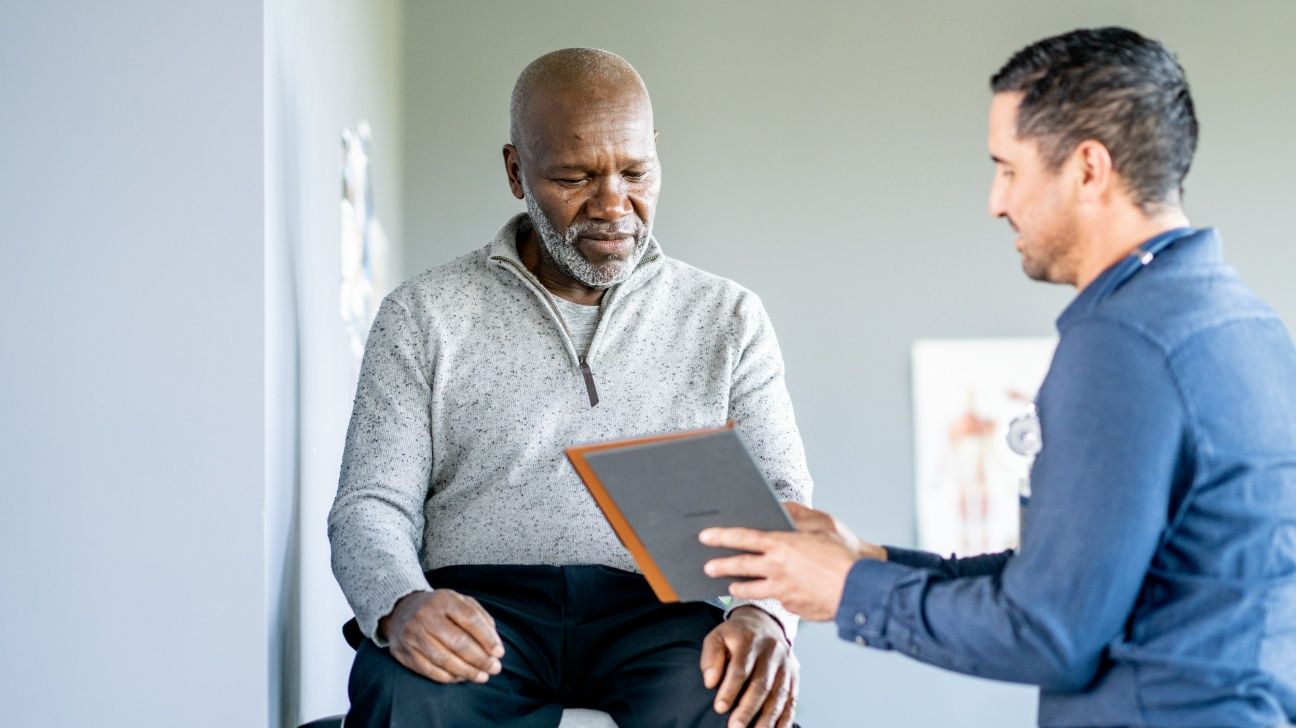 Middle aged male speaking with a healthcare professional in a clinical setting