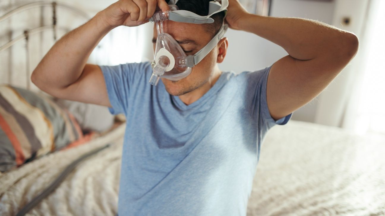 Male placing CPAP machine on face