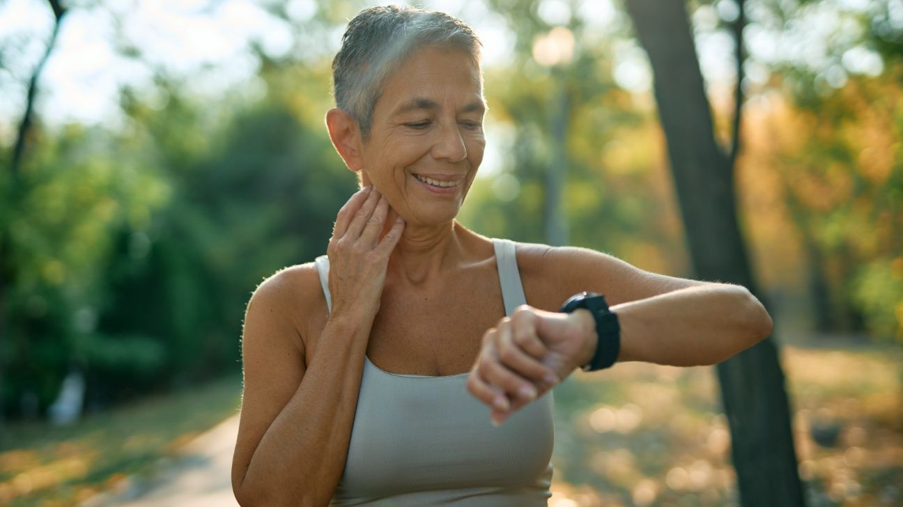 Older female checking heart rate on fitness tracker