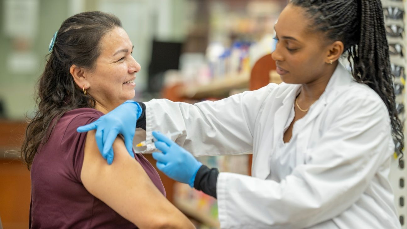 Female receives flu shot from pharmacist