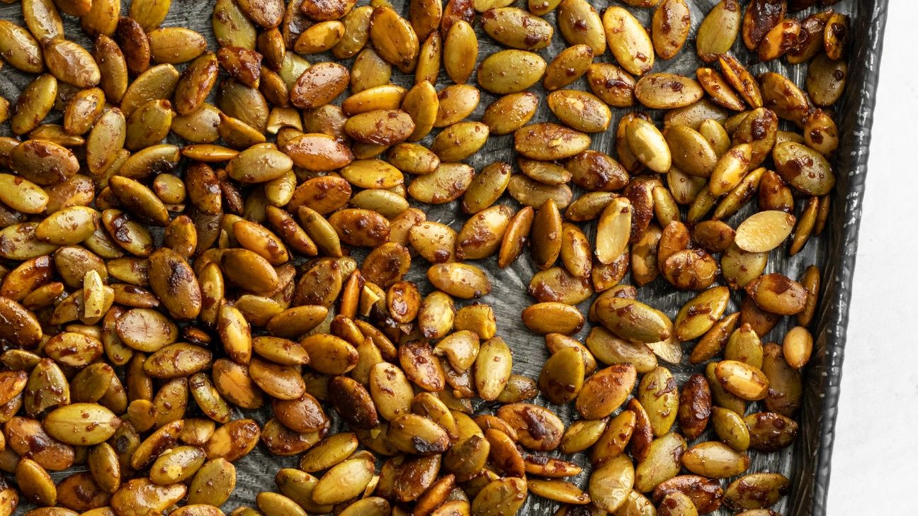 Toasted and spiced pumpkin seeds on a baking sheet