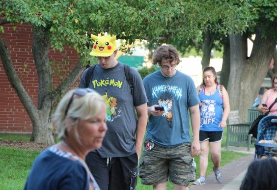 A couple of people wearing Pokemon gear, clearly playing Pokemon.