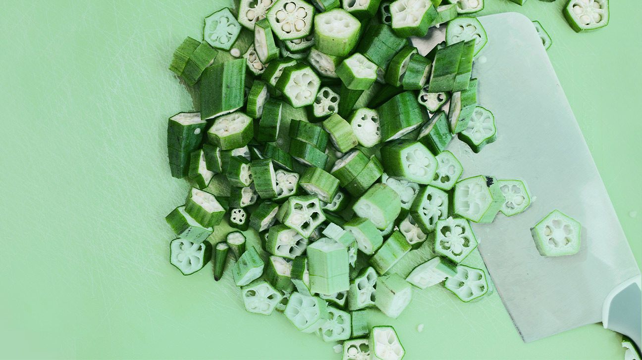 Chopped okra on a lime green background