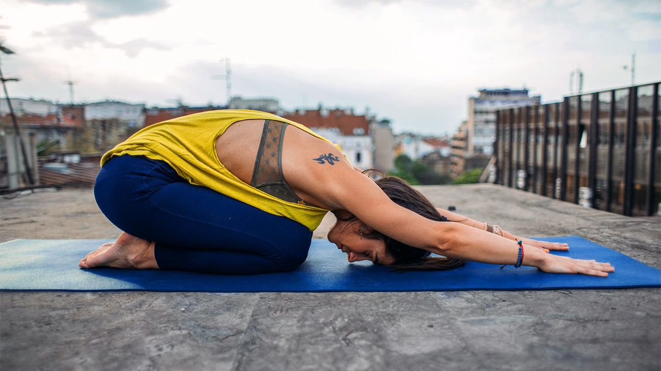 woman with a new tattoo doing yoga