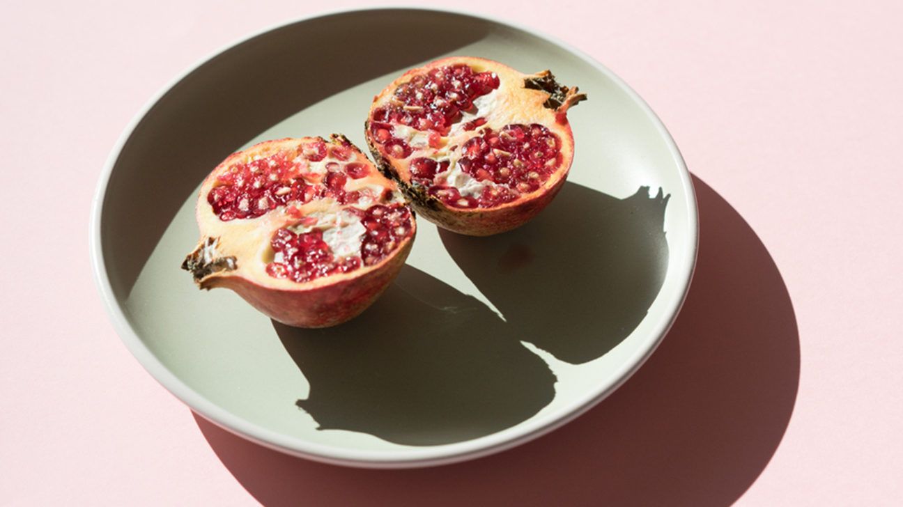 a halved pomegranate in a bowl