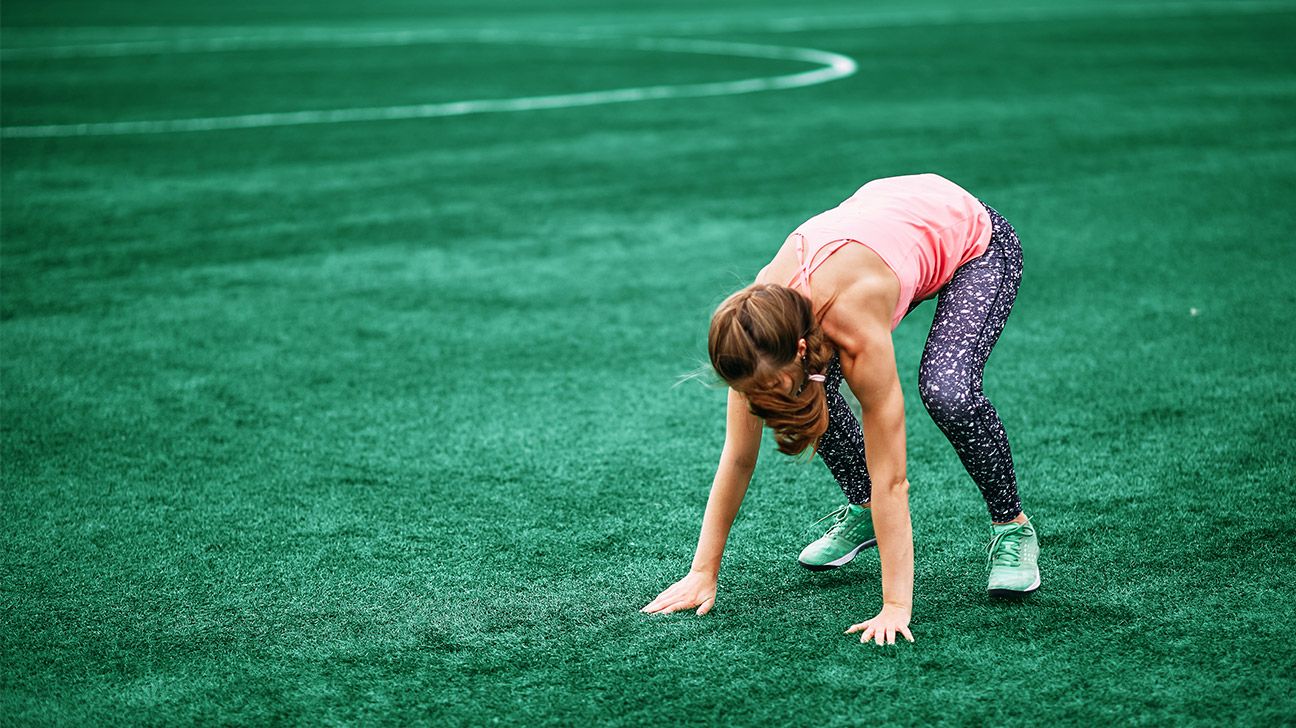 woman doing a burpee on grass