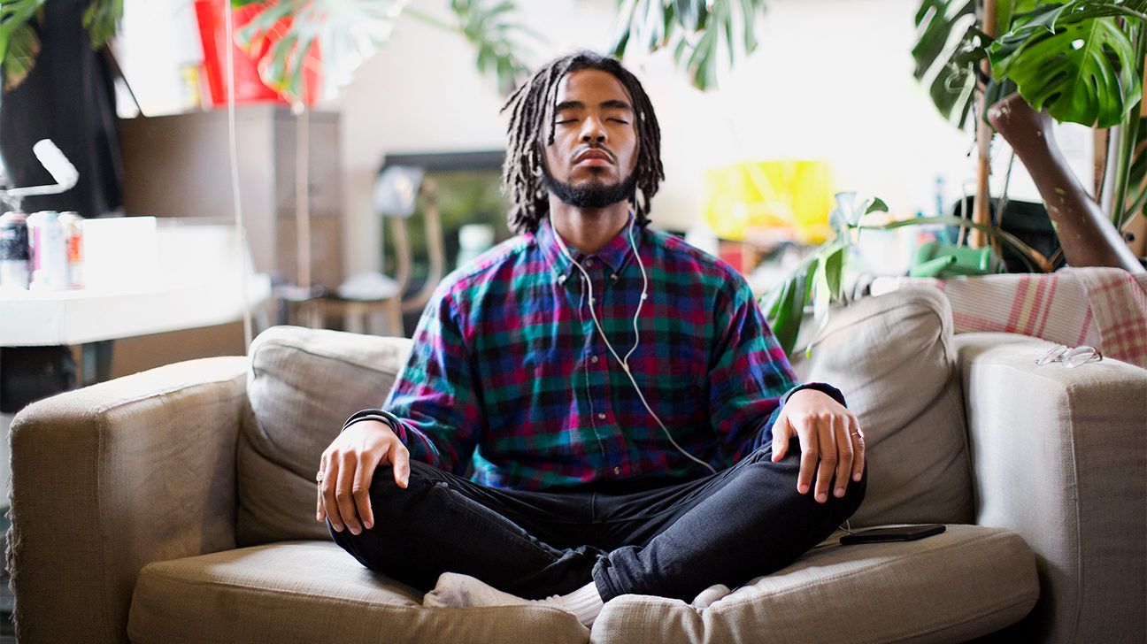 man meditating on couch