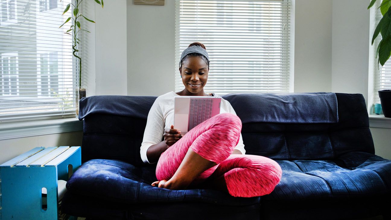 woman reading blood work results on couch at home