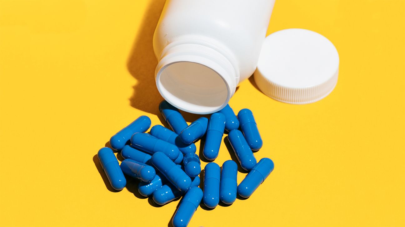 Blue Pills And Bottle On A Yellow Background